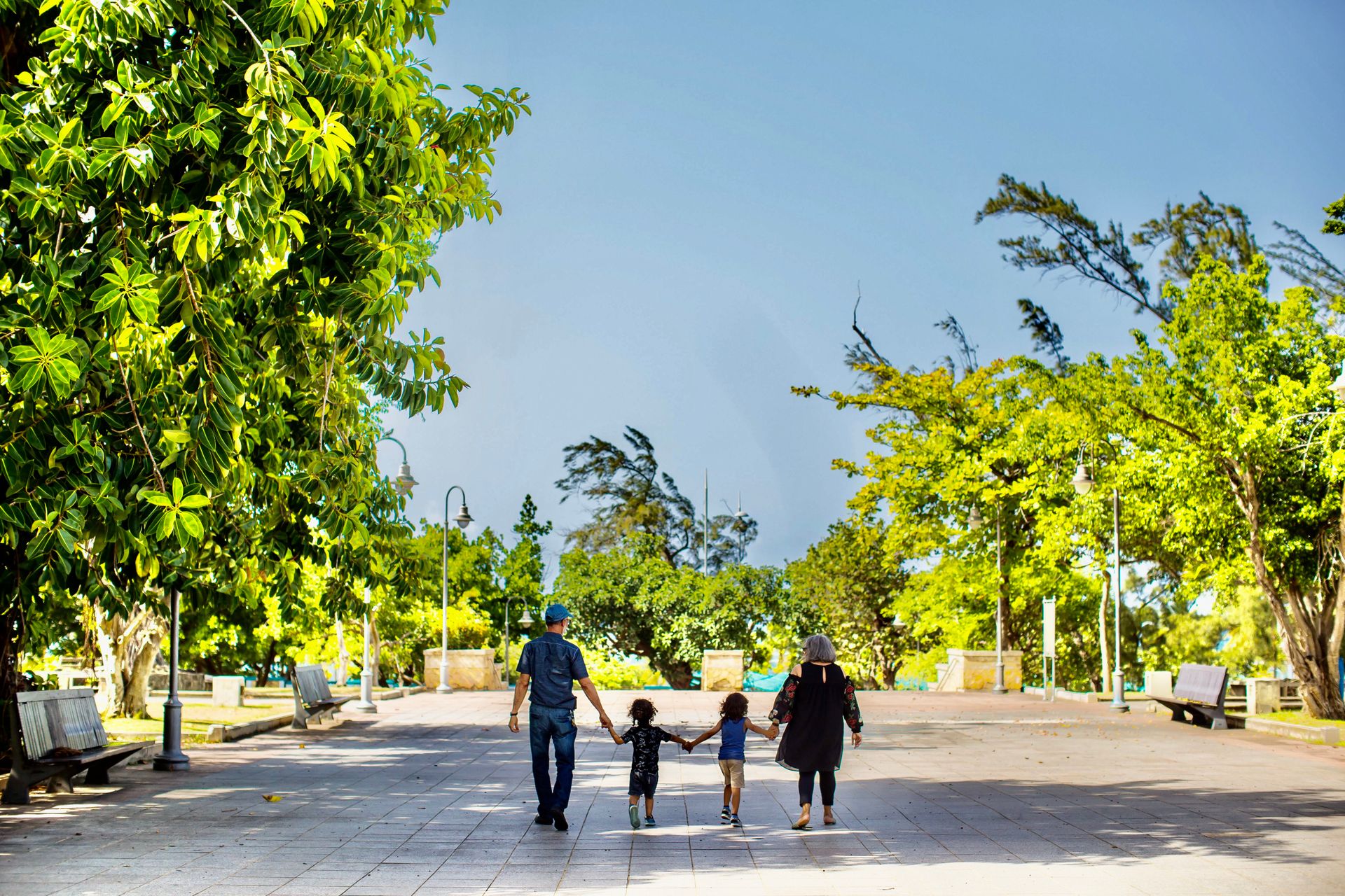 A family walking through a landscaped garden path inside a master-planned residential community in Cavite