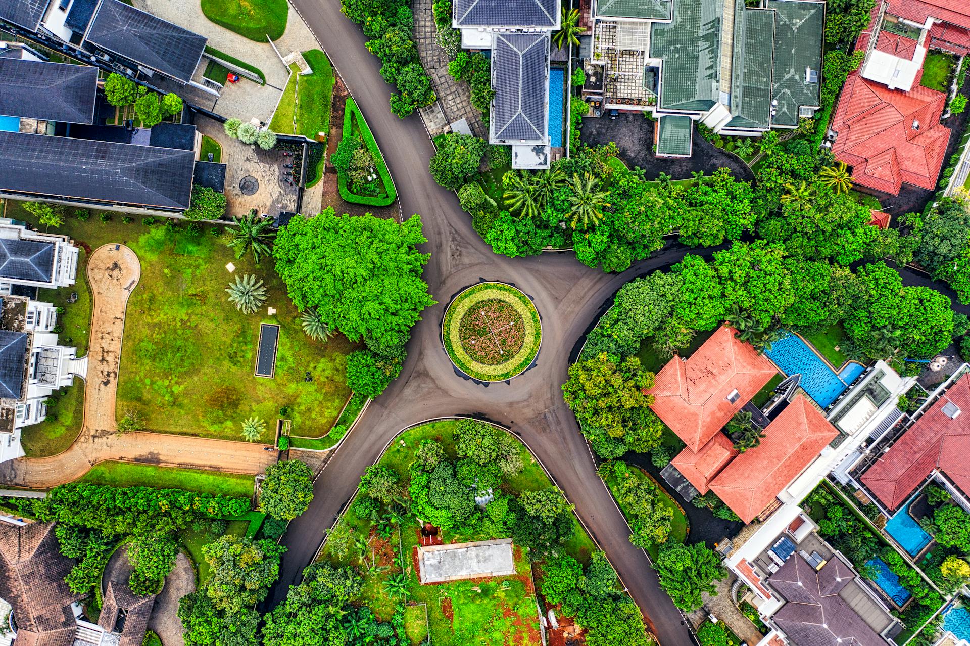 Aerial view of a residential subdivision in Cavite showing rows of single-family houses with private lots alongside a nearby mid-rise condo building