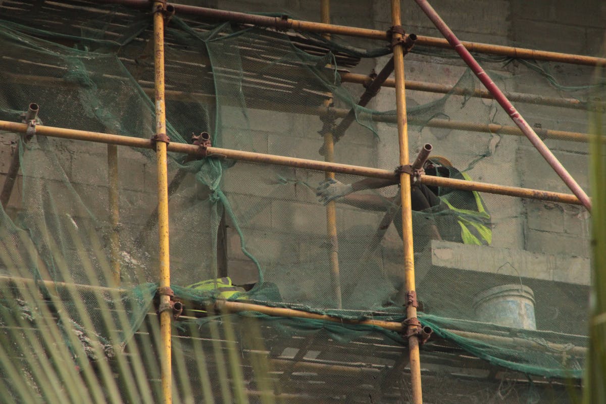Construction site of a mid-rise condominium building with active scaffolding and structural work in progress