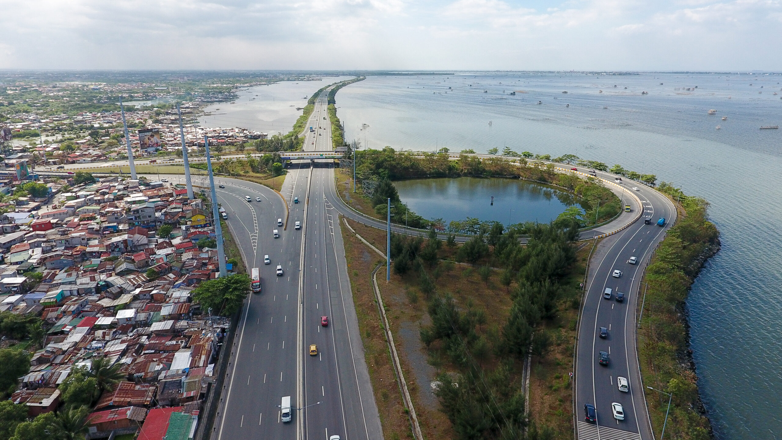 CAVITEX Manila-Cavite Expressway during morning rush hour, with cars merging near the Zapote interchange